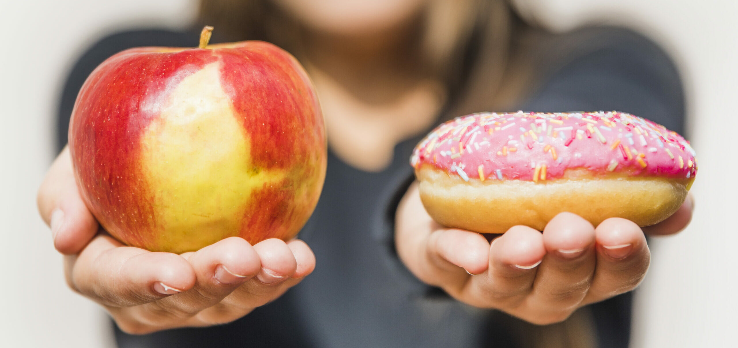 Vrouwenhand houdt een appel vast die als donut is gesneden – bewust omgaan met eten bij ADHD